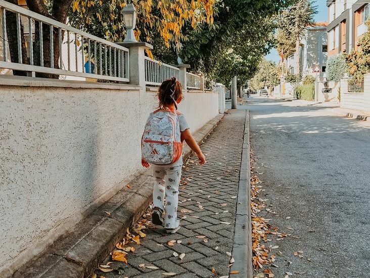 child walking down suburban street in autumn