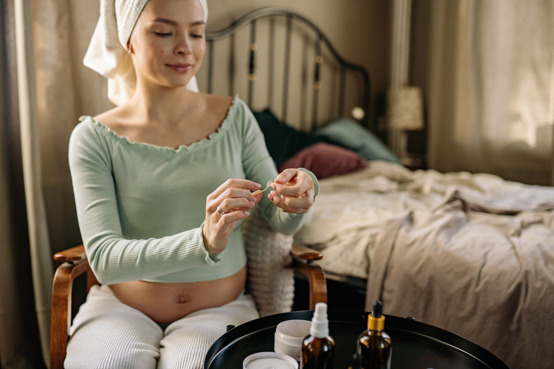 a pregnant woman using a skin care product
