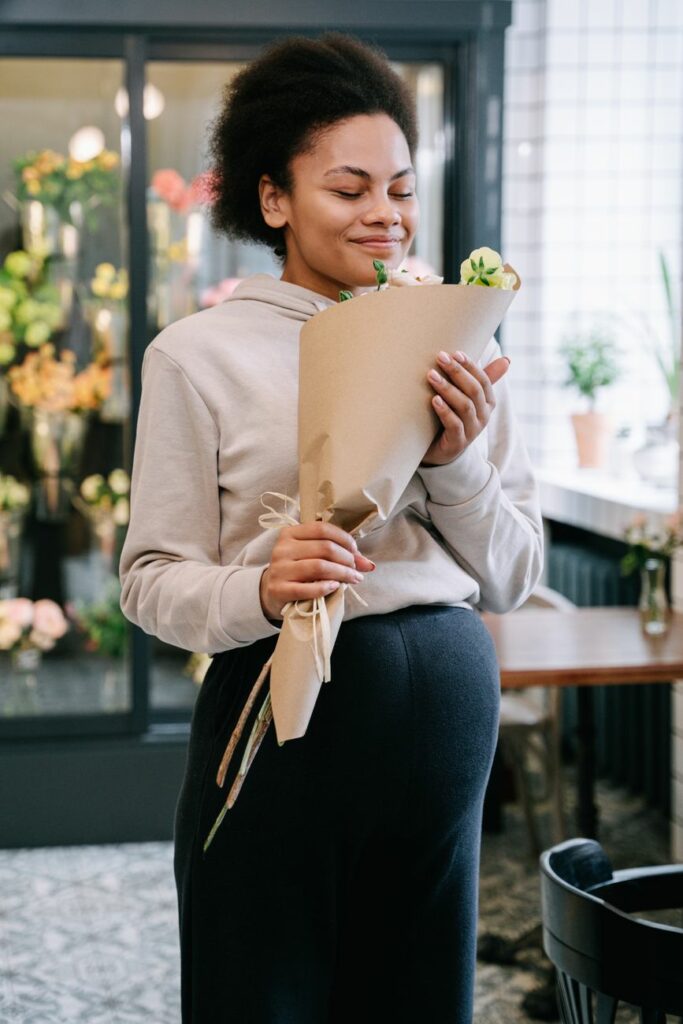 a pregnant woman holding a bouquet of flowers